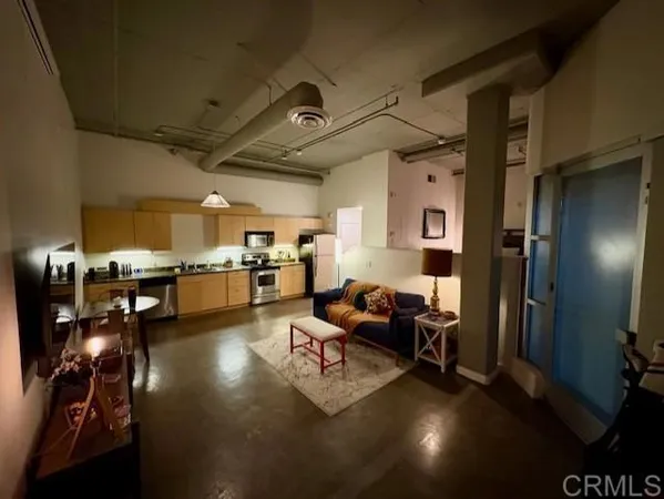 a living room with lots of furniture and kitchen view