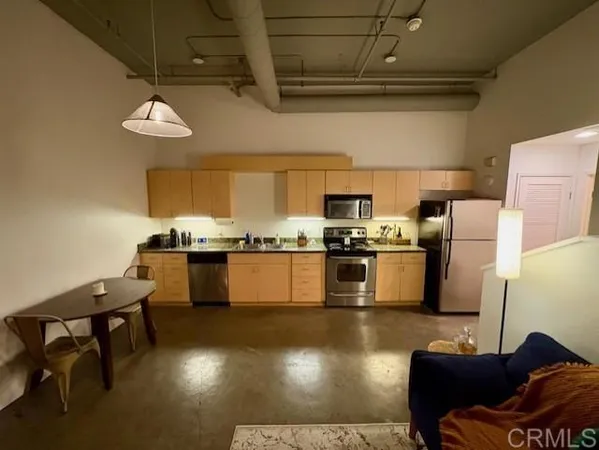 a kitchen with granite countertop stainless steel appliances and wooden floors