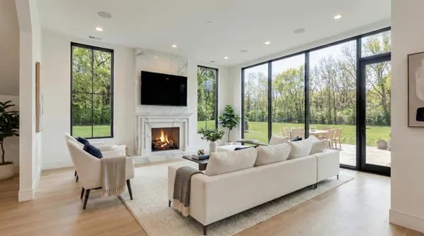 a living room with fireplace furniture large window and a flat screen tv