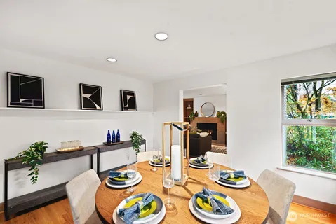 a view of a dining room with furniture a rug and wooden floor