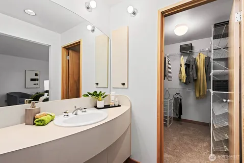 a en suite bathroom with a granite countertop sink and a mirror