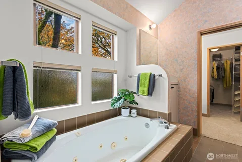 a bathroom with a tub and a large mirror