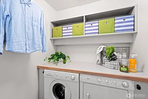 a utility room with stainless steel appliances cabinets and a window