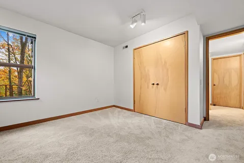 an empty room with windows and closet
