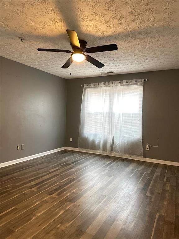16103 Waldrop Cove Decatur, GA 30034 - Photo 16 of 17 an empty room with wooden floor fan and windows