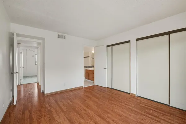 a view of empty room with wooden floor
