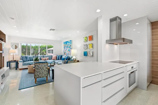 a large white kitchen with a large window