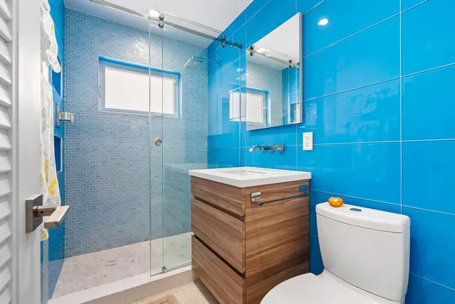 a bathroom with a granite countertop toilet a sink and a mirror