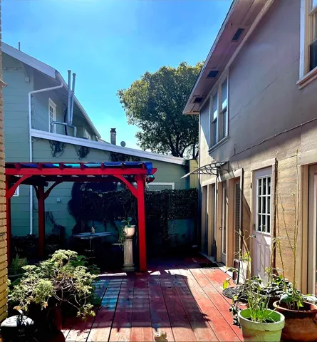 a view of a backyard with table and chairs potted plants