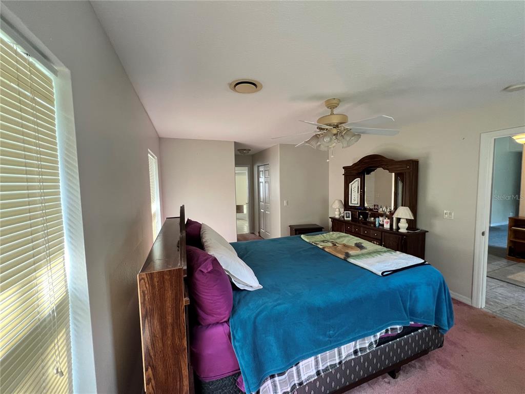 1995 East Newhaven Street Inverness, FL 34453 - Photo 44 of 48 a bedroom with a bed mirror and a window
