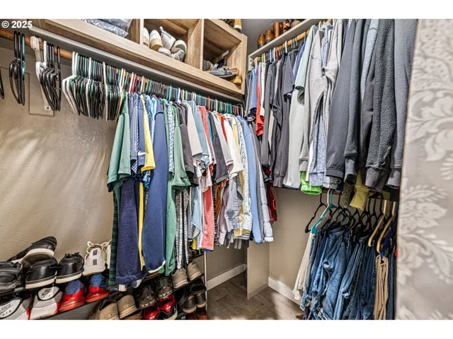 a view of walk in closet with clothes and shoes