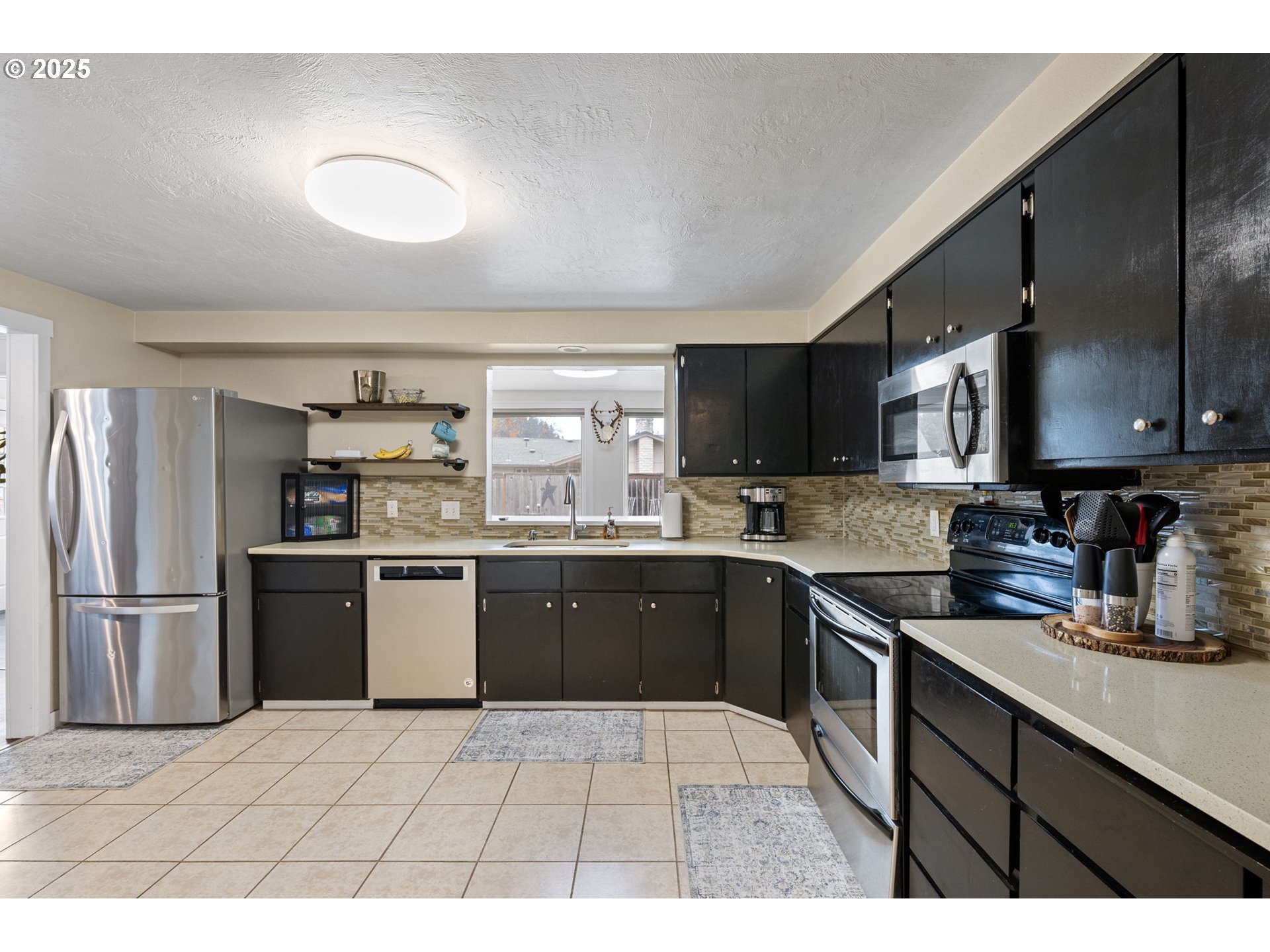 296 65th Street Springfield, OR 97478 - Photo 9 of 33 a kitchen with stainless steel appliances granite countertop a sink dishwasher stove top oven and refrigerator