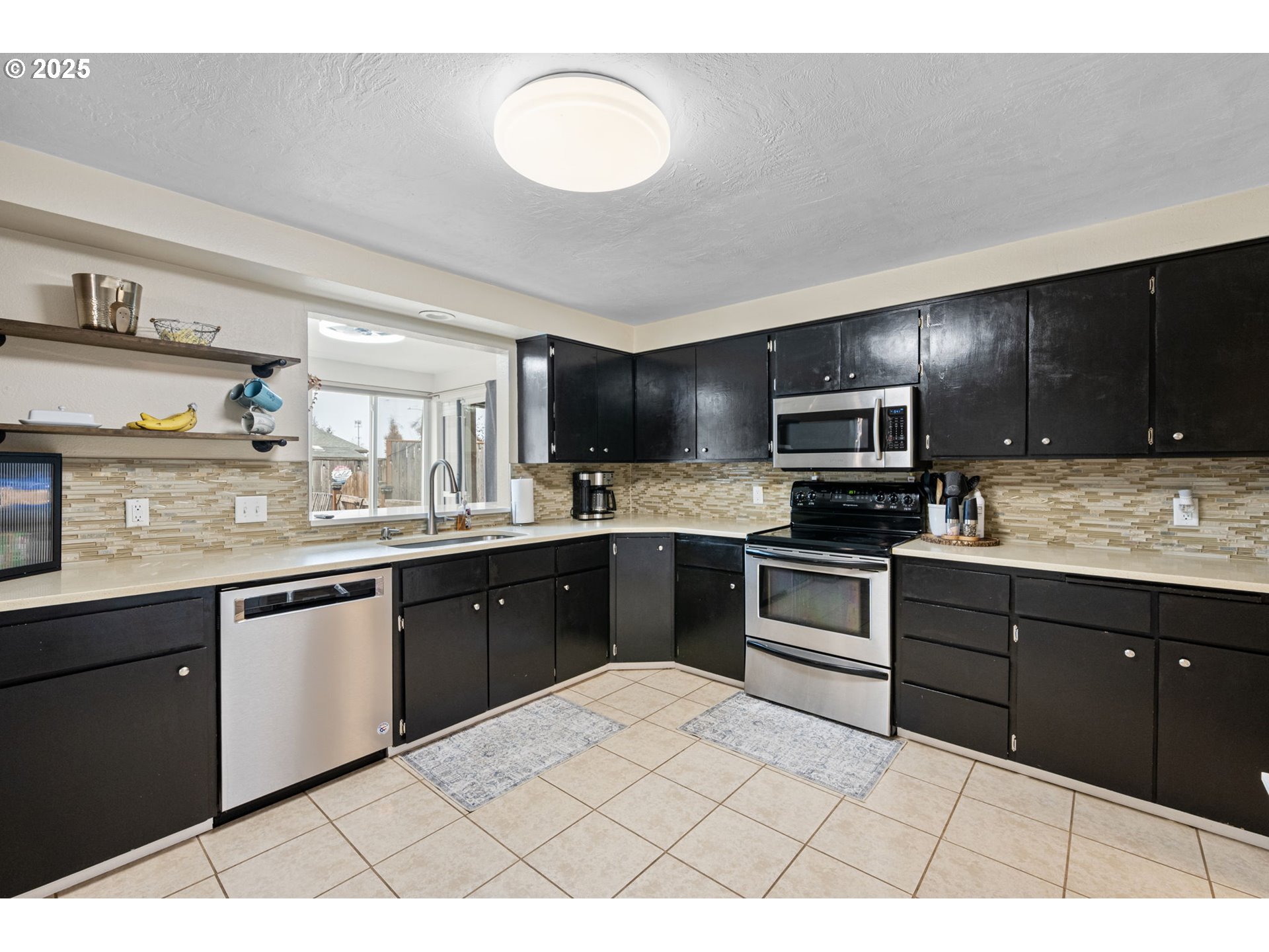 296 65th Street Springfield, OR 97478 - Photo 10 of 33 a kitchen with stainless steel appliances kitchen island granite countertop a sink dishwasher stove top oven and cabinets
