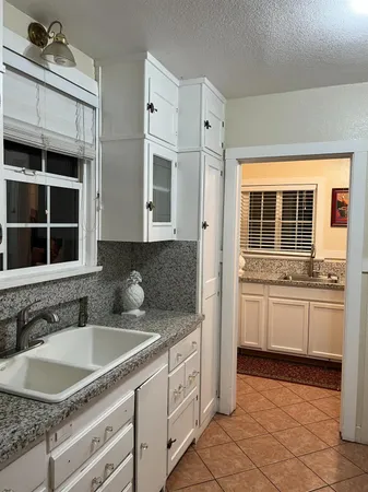 a kitchen with granite countertop a sink and a stove