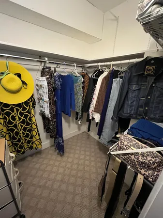 a view of walk in closet with clothes and shoes