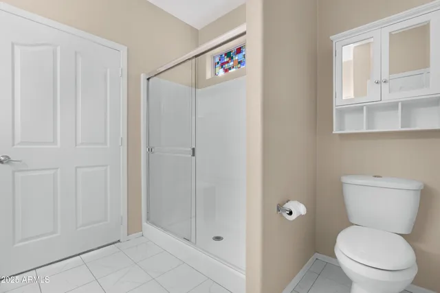 a bathroom with a toilet and a shower
