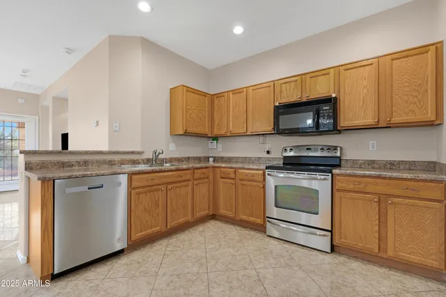 a kitchen with granite countertop a stove top oven microwave and cabinets