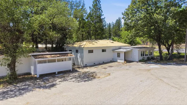 a view of a house with backyard space and trees