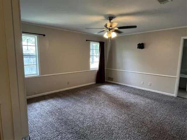 an empty room with closet and a ceiling fan