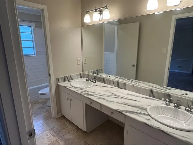 a spacious bathroom with a double vanity sink mirror and shower