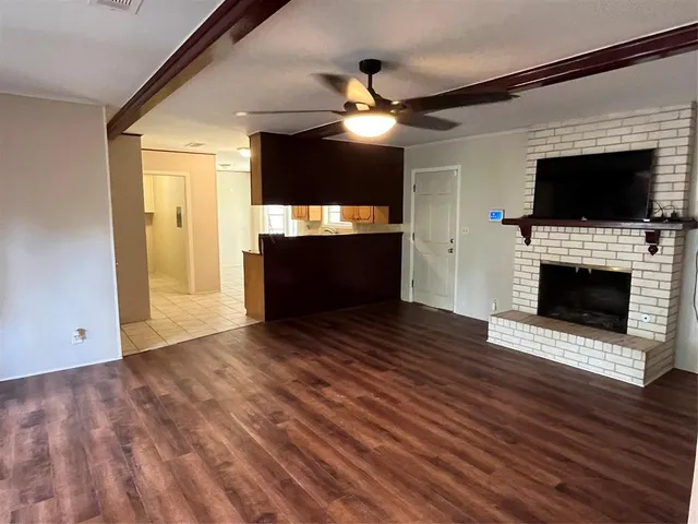 a view of empty room with wooden floor and fireplace