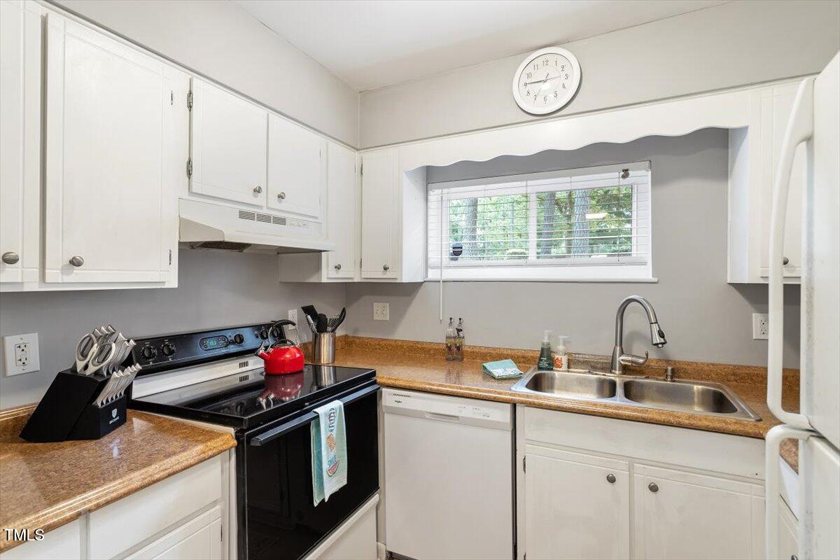 712 Godwin Court Raleigh, NC 27606 - Photo 9 of 27 a kitchen with stainless steel appliances granite countertop a sink stove and cabinets