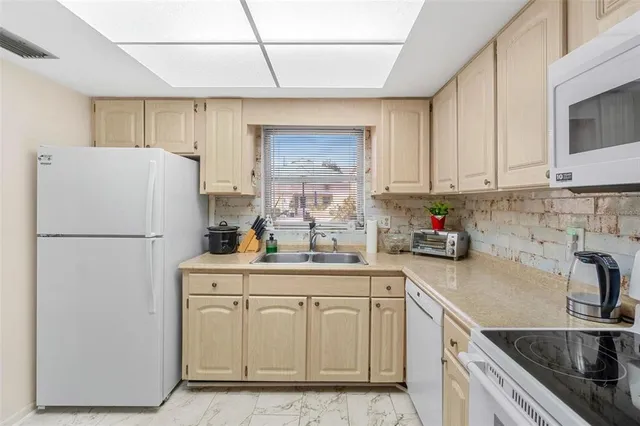 a kitchen with white cabinets and white appliances