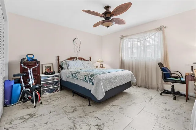 a bedroom with a bed a chandelier and dresser