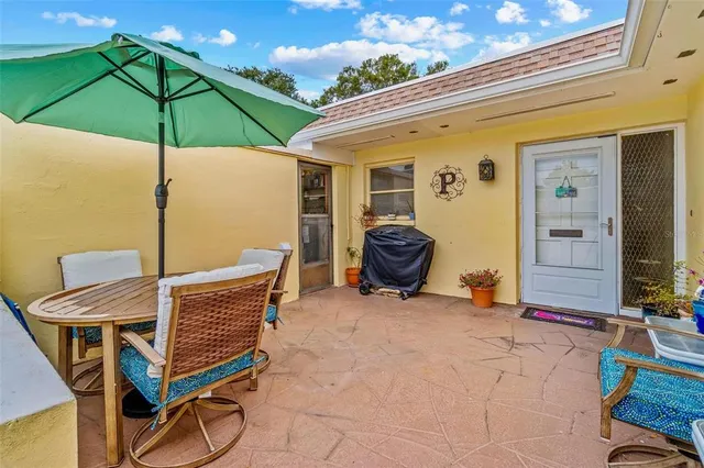a view of a patio with a table and chairs under an umbrella