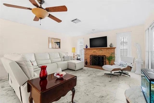 a living room with furniture a fireplace and a flat screen tv