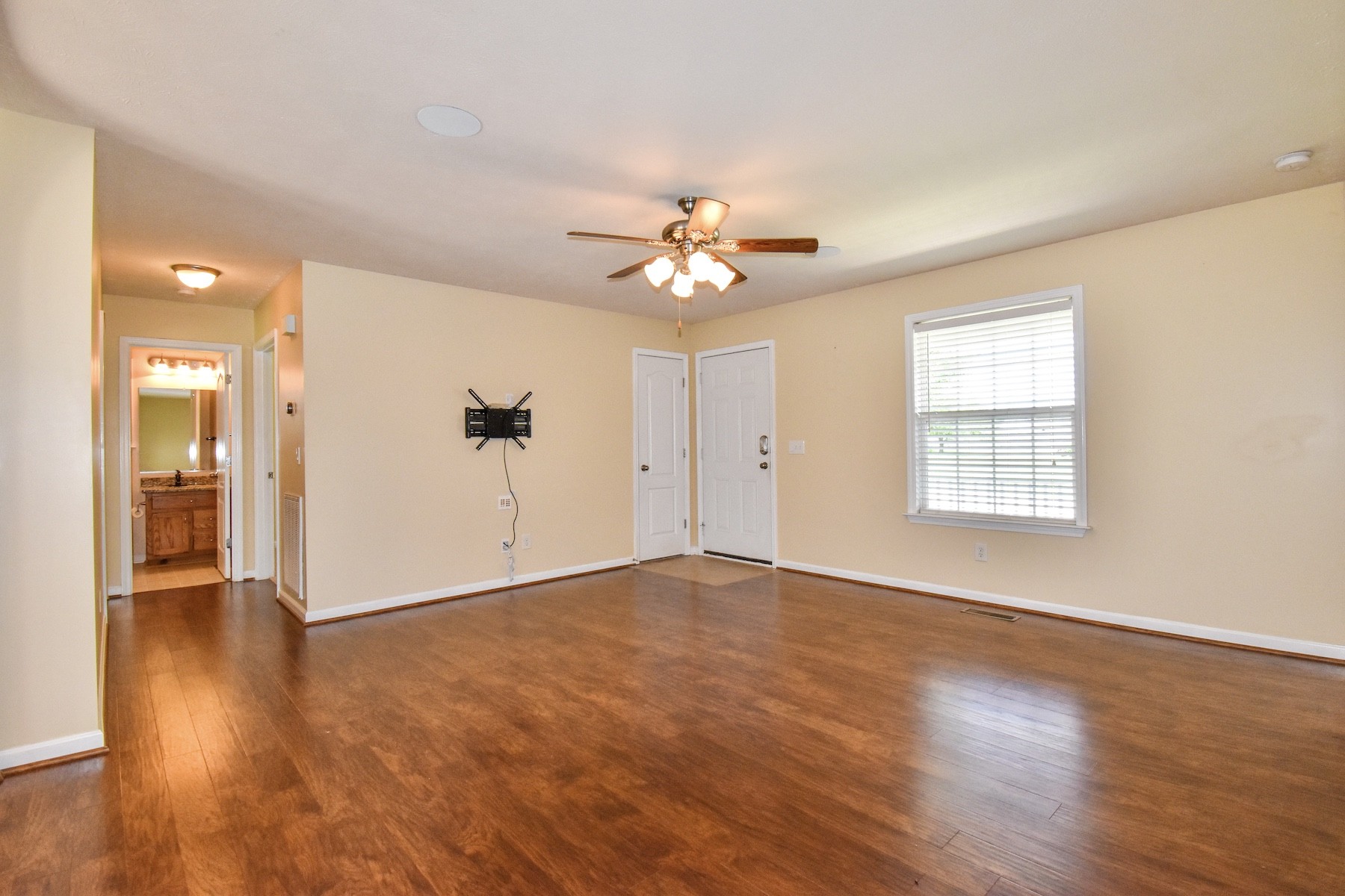 1621 Robert Road Columbia, TN 38401 - Photo 3 of 34 an empty room with wooden floor chandelier fan and windows