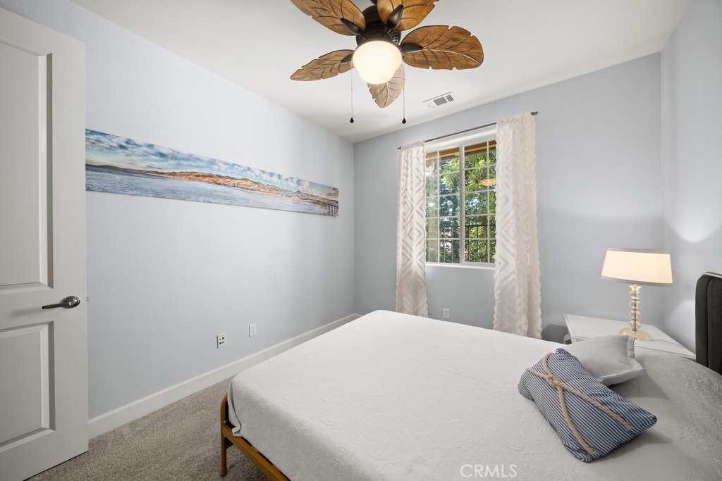 1156 Spring Azure Way Nipomo, CA 93444 - Photo 23 of 60 a bedroom with a bed and a chandelier