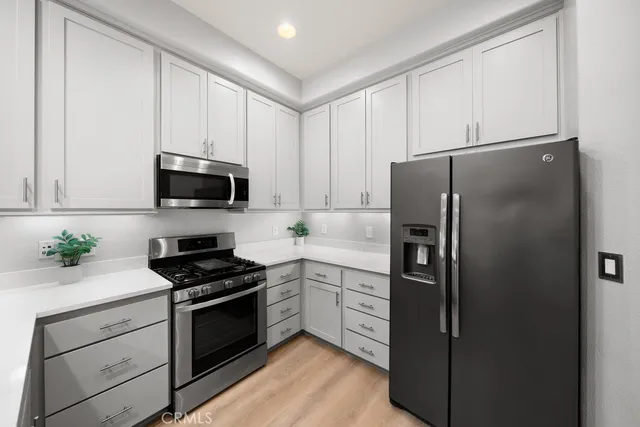 a kitchen with white cabinets and stainless steel appliances