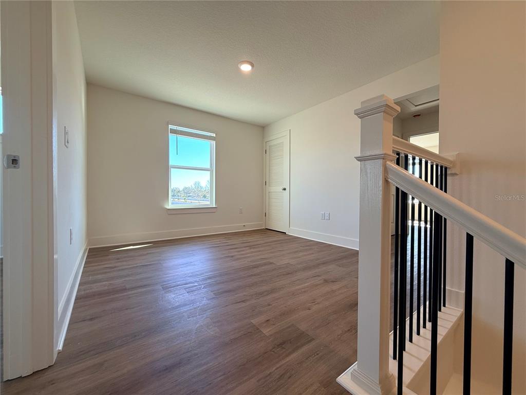 13622 Wolfpack Road Hudson, FL 34667 - Photo 6 of 7 an empty room with wooden floor and windows
