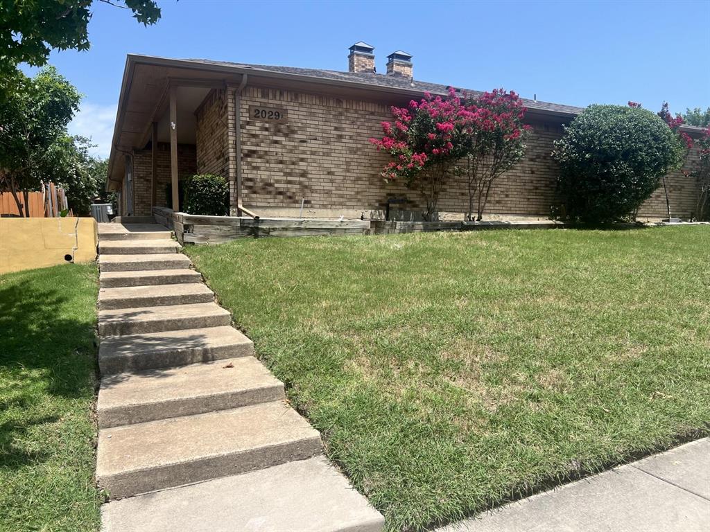 2029 Springwood Place, Unit A Carrollton, TX 75006 - Photo 1 of 9 a front view of a house with a yard
