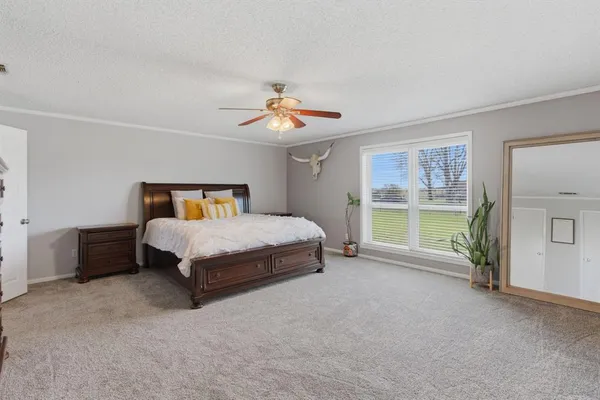 a bedroom with a bed a window and a chandelier