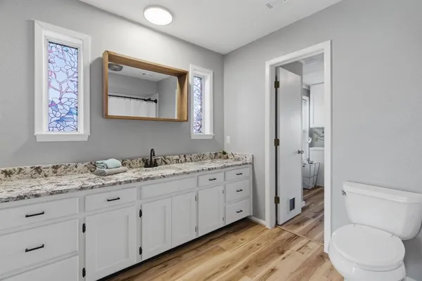 a bathroom with a granite countertop sink and a mirror