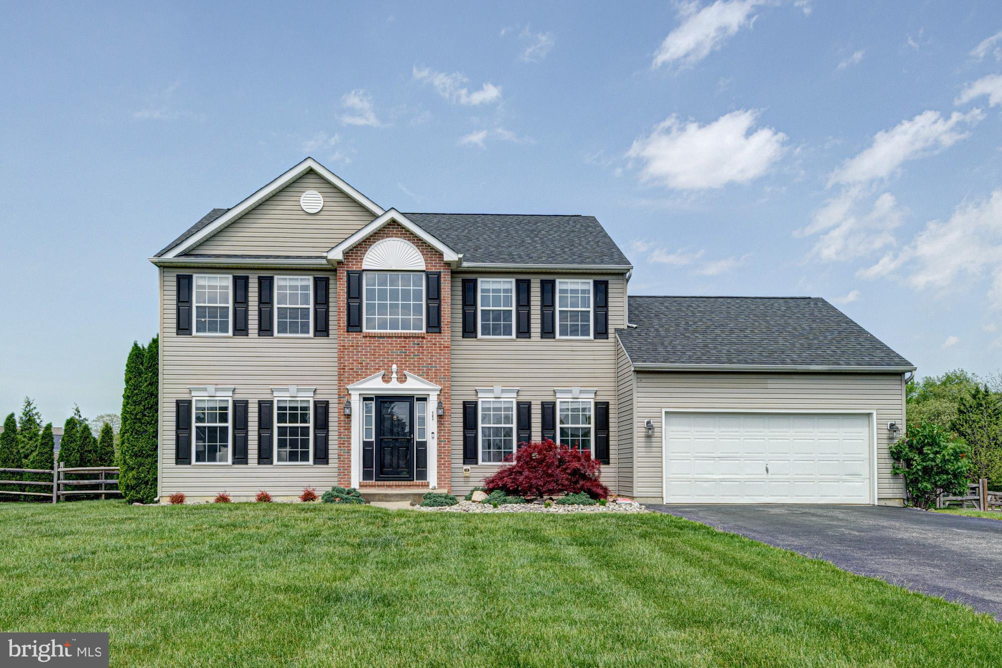 a front view of a house with a garden and yard
