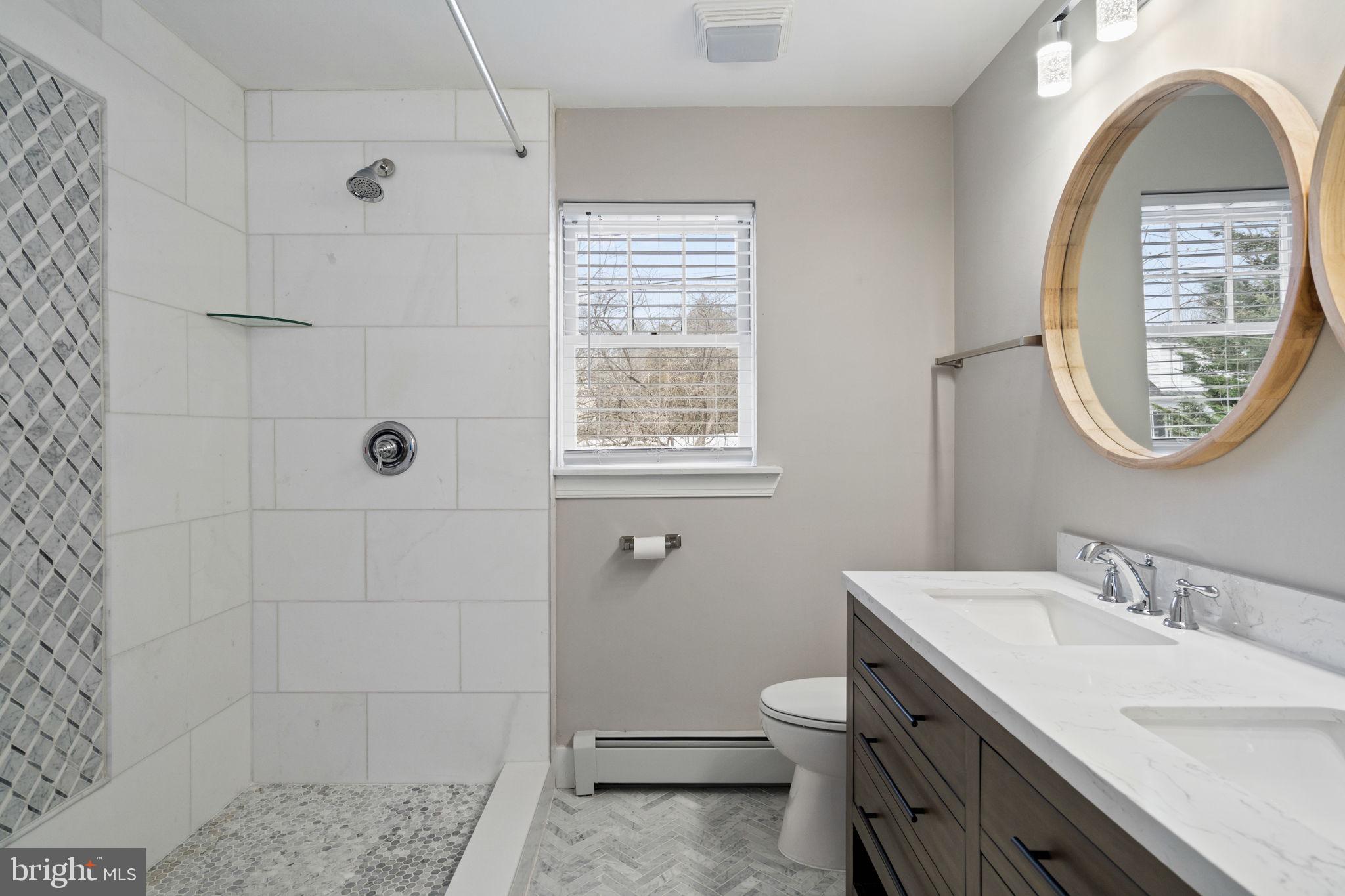 383 Upper Gulph Road Wayne, PA 19087 - Photo 26 of 42 a bathroom with a granite countertop toilet a sink and mirror