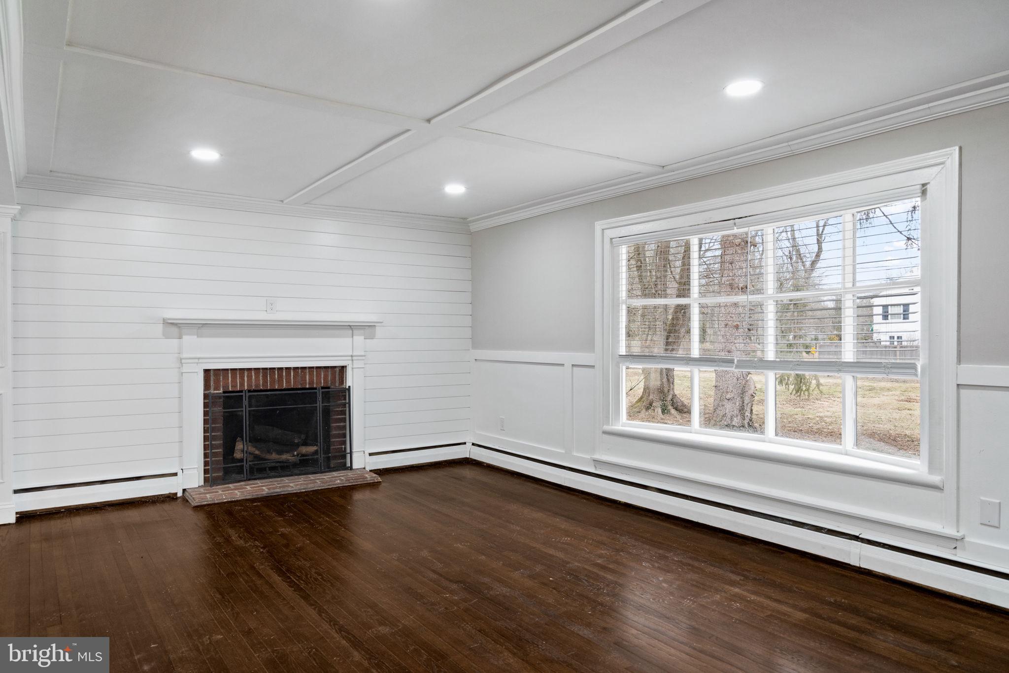 383 Upper Gulph Road Wayne, PA 19087 - Photo 8 of 42 an empty room with wooden floor fireplace and windows