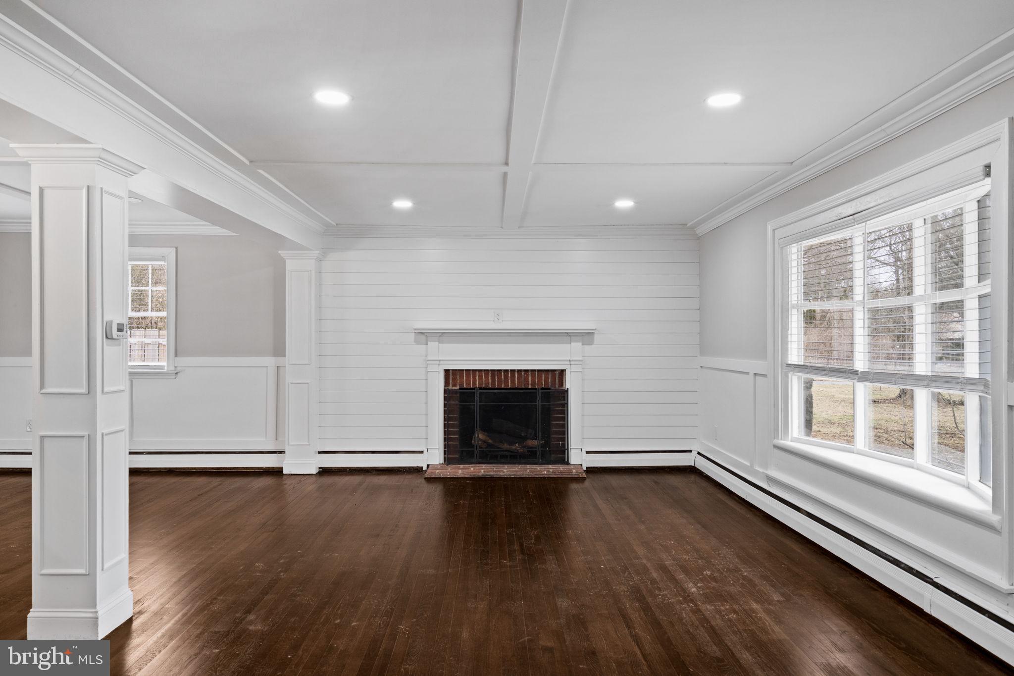 383 Upper Gulph Road Wayne, PA 19087 - Photo 9 of 42 an empty room with wooden floor fireplace and windows