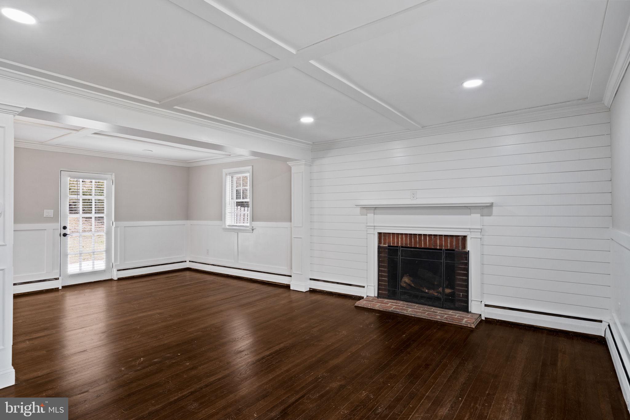 383 Upper Gulph Road Wayne, PA 19087 - Photo 10 of 42 an empty room with wooden floor fireplace and windows