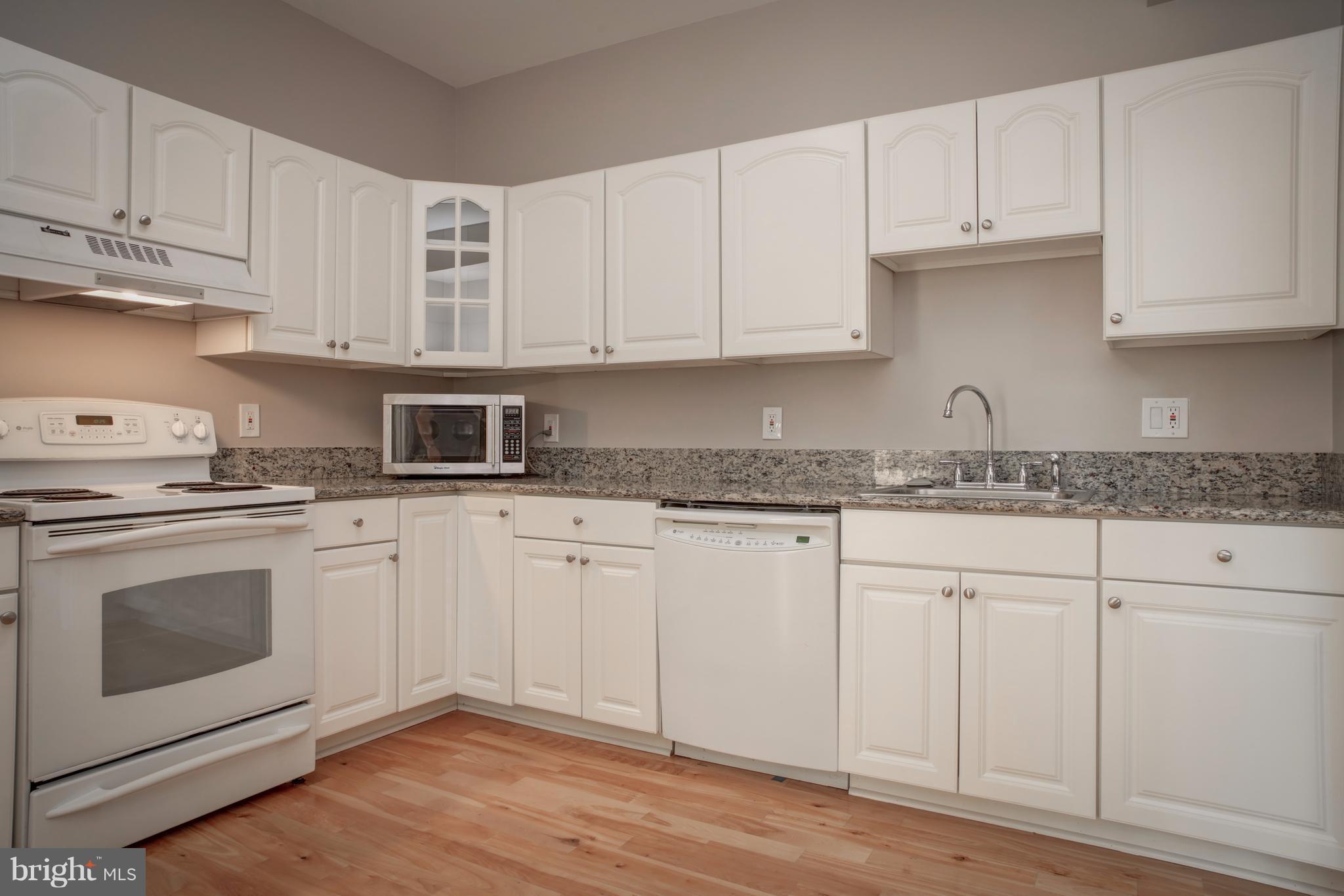 11616 Ivystone Court, Unit 301 Reston, VA 20191 - Photo 2 of 29 a kitchen with granite countertop white cabinets and white appliances