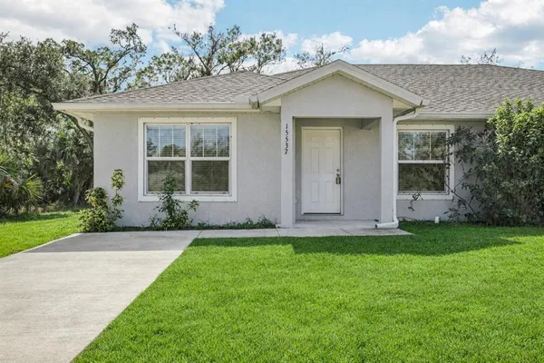 a front view of a house with a garden and yard