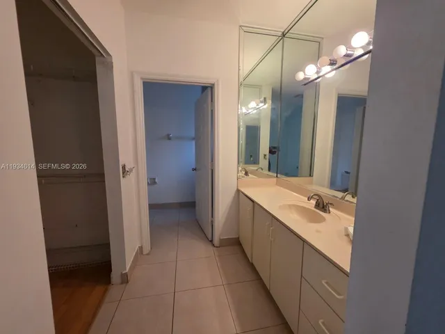 a bathroom with a double vanity sink and mirror with shower