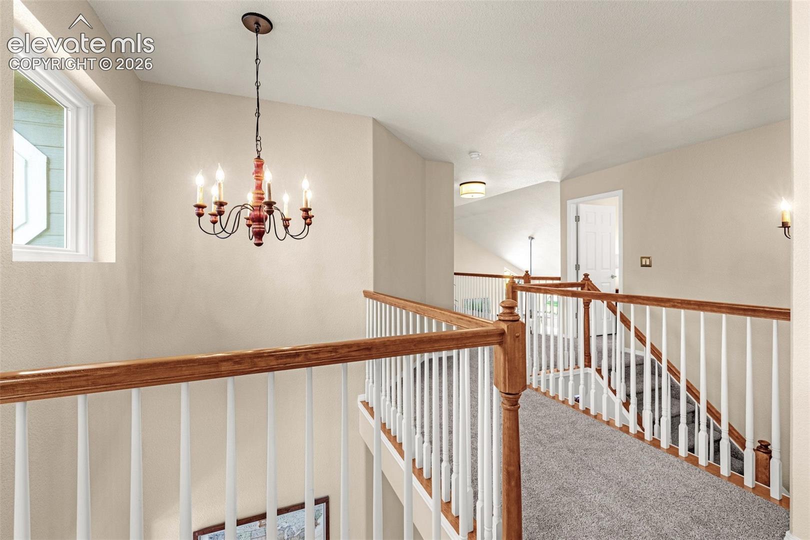 7985 Orchard Path Road Colorado Springs, CO 80919 - Photo 39 of 50 Upper-level landing with wood-finish handrails, white balusters, and a carpeted walkway