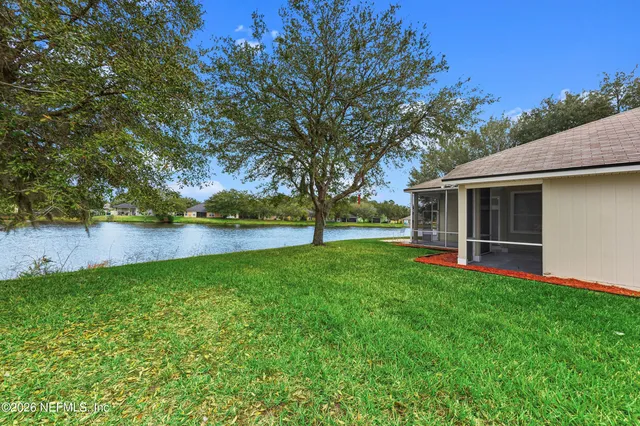 a view of a backyard with table and chairs and a large tree
