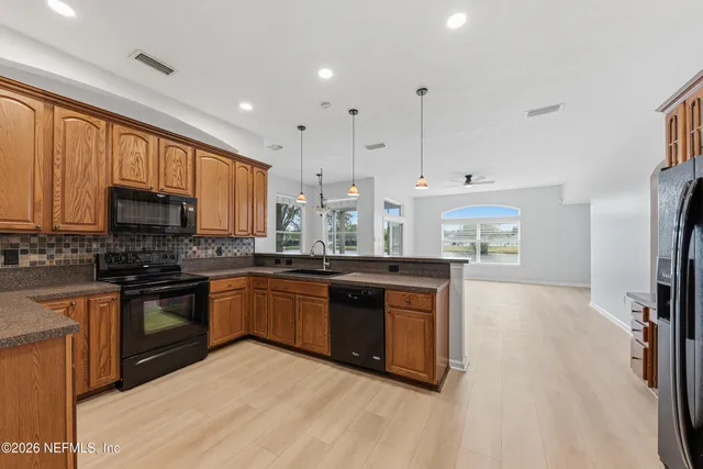 a large kitchen with stainless steel appliances granite countertop a stove a sink dishwasher and a refrigerator