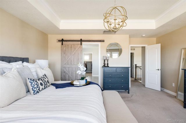 a bedroom with a bed and a chandelier