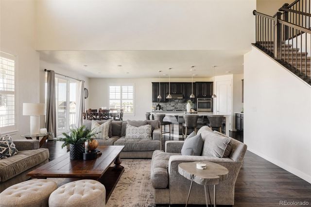 a living room with furniture kitchen view and a window